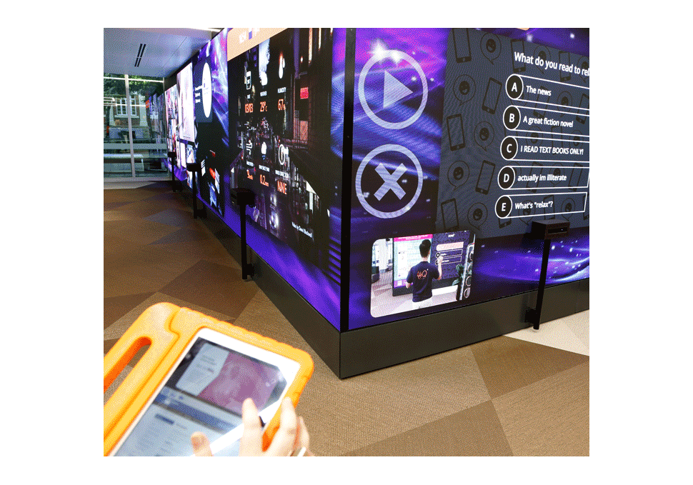 Graphic design, student sending content from iPad to large LED screen at HiQ Gardens Point QUT, with digital content by Maya Walker