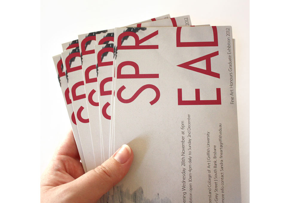 Graphic design, hand holding stack of DL print invitations to QCA Graduate Exhibition 2012 by Maya Walker